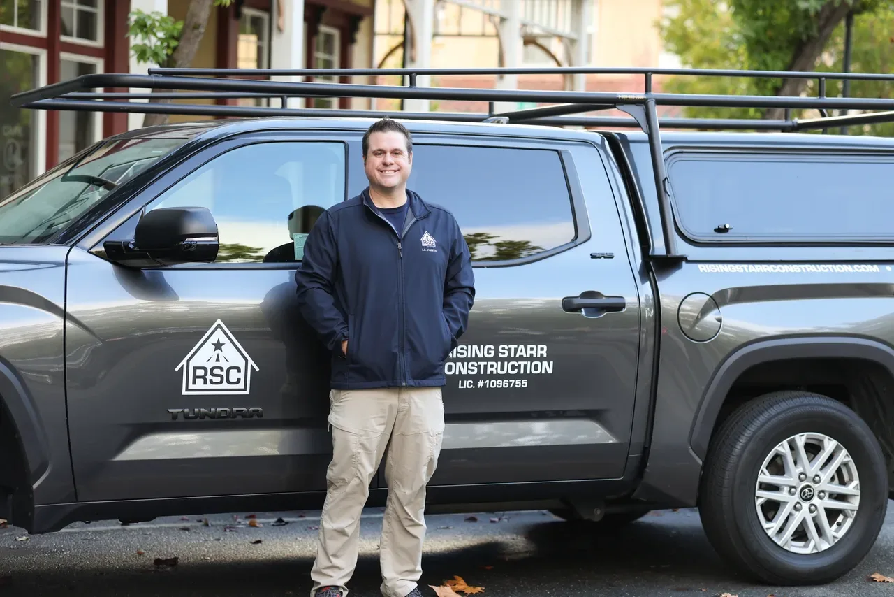 A Rising Starr Construction team member beside the company truck