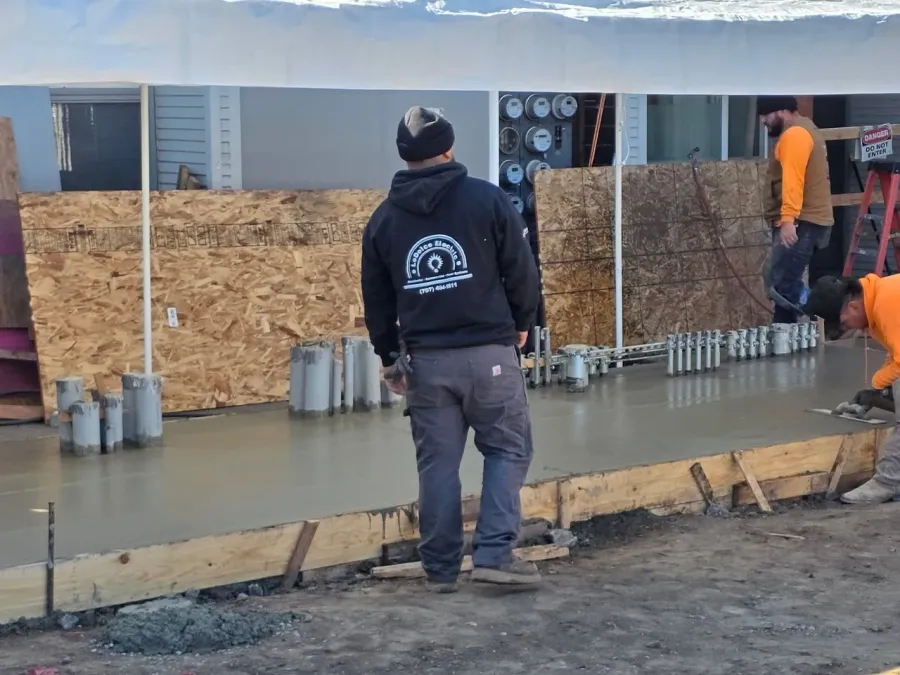 A LoDolce Electric crew member at a job site with electrical conduits and meter equipment