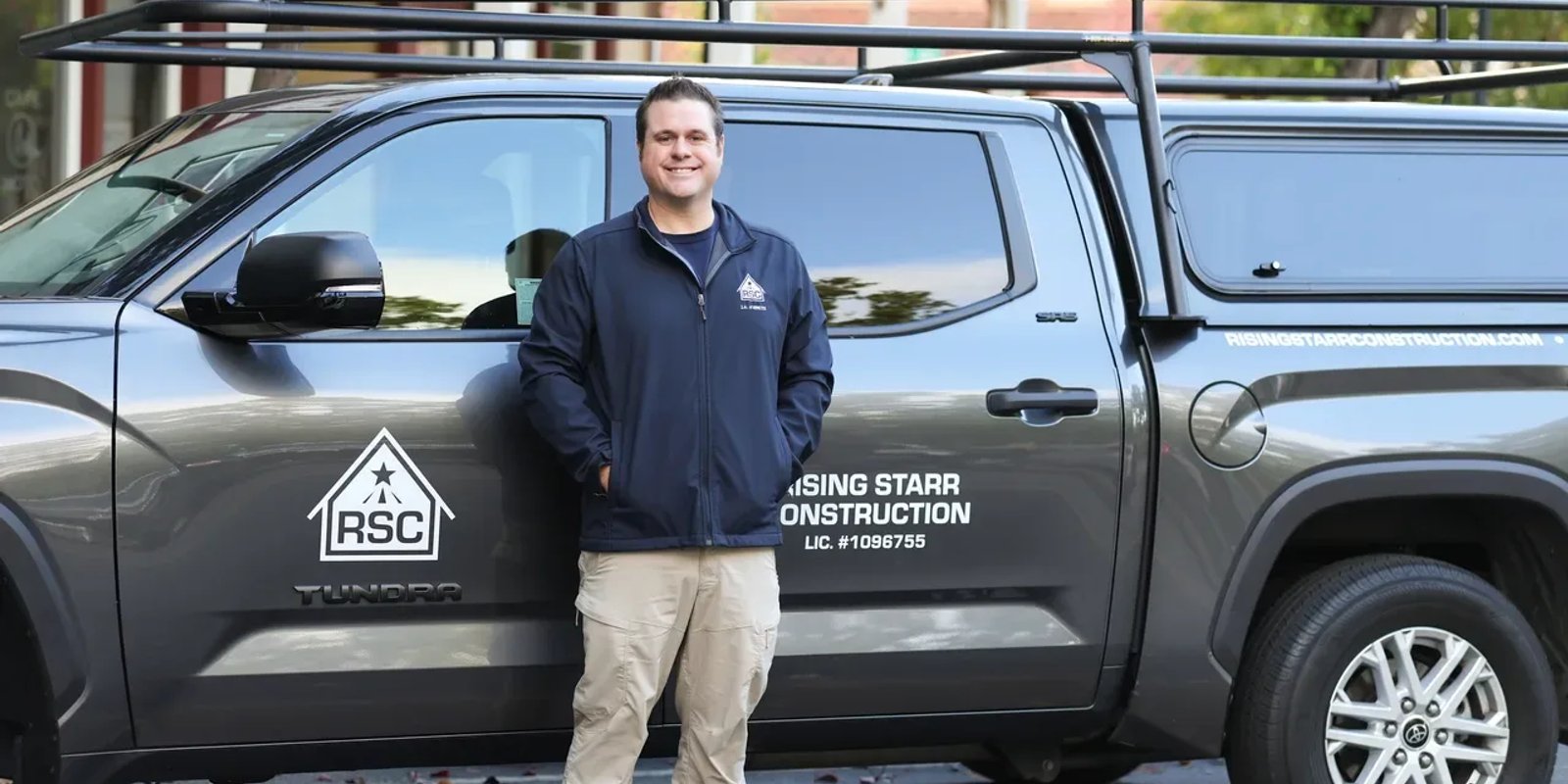 A Rising Starr Construction team member beside the company's branded work truck.